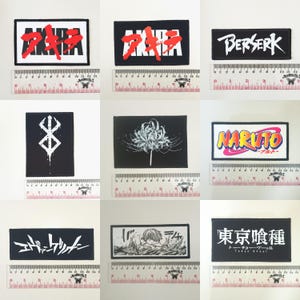 May include: Nine rectangular patches with various designs. The patches feature text and graphics from anime and manga series. The patches are black and white, with some featuring red, yellow, and orange accents. Each patch is approximately 7.6 cm wide.