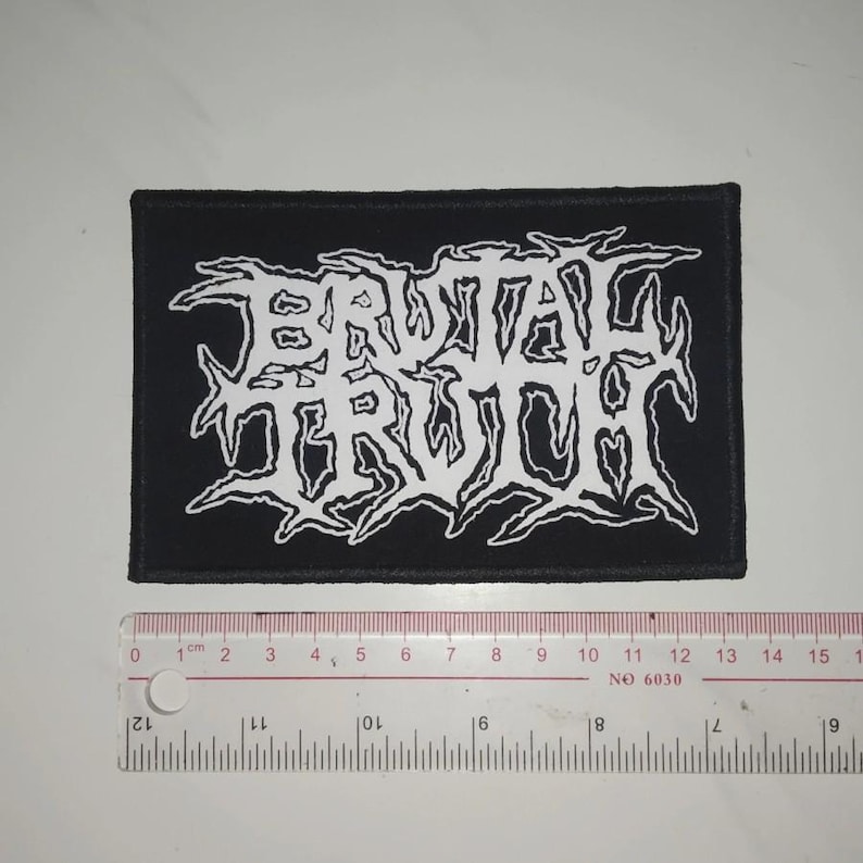 May include: Black and white embroidered patch featuring the band name "Brutal Truth" in a stylised font.