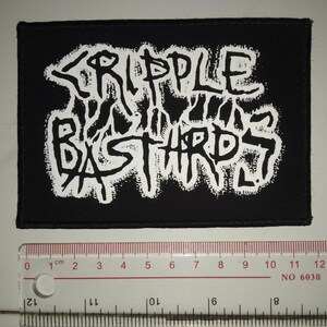 May include: Black and white embroidered patch with the text "CRIPPLE BASTARDS" in a stylised font.
