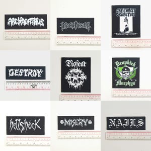 Pode incluir: Dez patches bordados em preto e branco com nomes de bandas, incluindo "Archgoat", "Black Breath", "Destroy", "Disfear", "HellShock", "Misery", "Nails", "Dropkick Murphys", "Capitalist Casualties" e "Raised Ignorant".