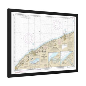 May include: Framed nautical chart of Ashtabula to Chardon River, featuring detailed coastlines, depth soundings, and navigational aids. The chart is in shades of beige, blue, and brown, with a black frame. Includes text: Ashtabula to Chardon River.