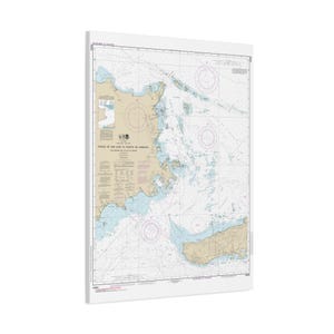 May include: A nautical chart print of the coast of Puerto Rico, featuring detailed lines, symbols, and text. The map shows the coastline in shades of tan and blue, with a white border. The chart is mounted on a white surface.