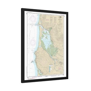 May include: Framed nautical chart of Tillamook Bay, Oregon. The chart features detailed information about the bay's topography, including depth soundings, navigational aids, and coastline details. The chart is framed in a black frame.