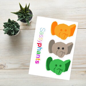 May include: Three colorful elephant head stickers with the text "Sassyphants" printed on a white background.