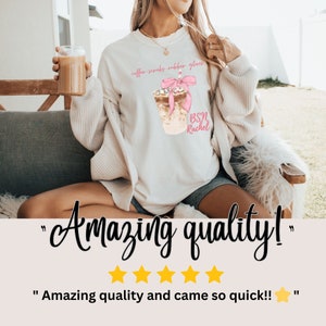 May include: Cream-colored sweatshirt with a graphic of an iced coffee drink with a pink bow and the text "coffee scrubs rubber gloves" and "BSN Rachel". The image also includes the text "Amazing quality!" and customer feedback.