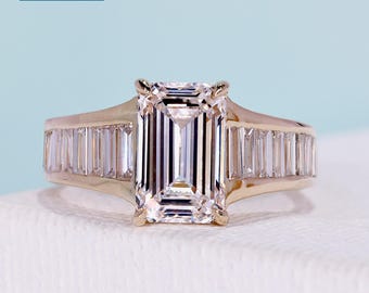 3.46tcw Emerald cut engagement ring with 4 claw prong, baguette side stones,14k yellow gold band. Features an IGI certified