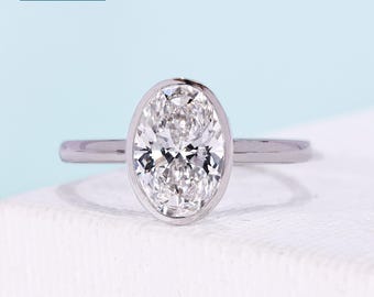 2ct Oval cut engagement ring with bezel setting, solitaire diamond, and 14k white gold band