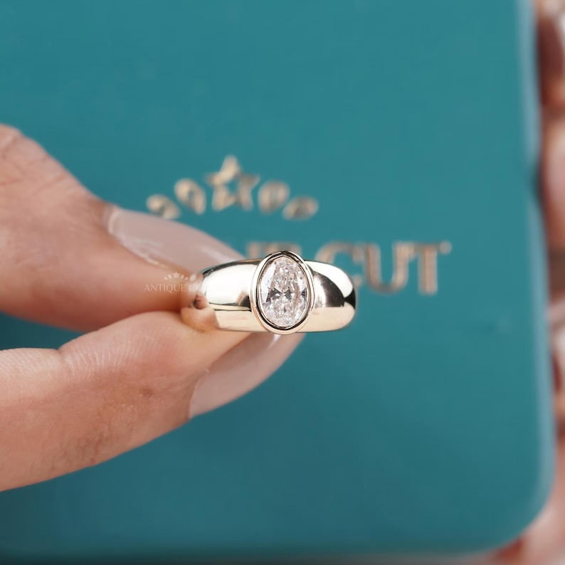Oval diamond ring with modern bezel setting in gold