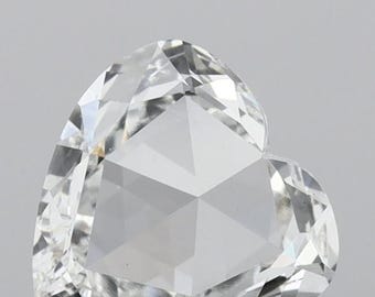 Könnte beinhalten: Ein herzförmiger, facettierter Diamant mit einem brillanten, klaren Aussehen. Der Edelstein hat einen komplexen, geometrischen Schliff, der das Licht reflektiert und einen funkelnden Effekt erzeugt. Der Diamant ist vor einem neutralen Hintergrund platziert, der seine Klarheit und Form hervorhebt.