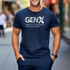 May include: A navy blue t-shirt with white text that reads "GENX raised on TV dinners & 2nd hand smoke".