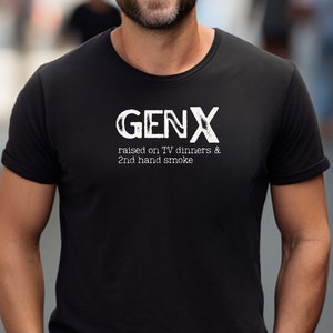 May include: Black t-shirt with white text that reads "GENX raised on TV dinners & 2nd hand smoke"
