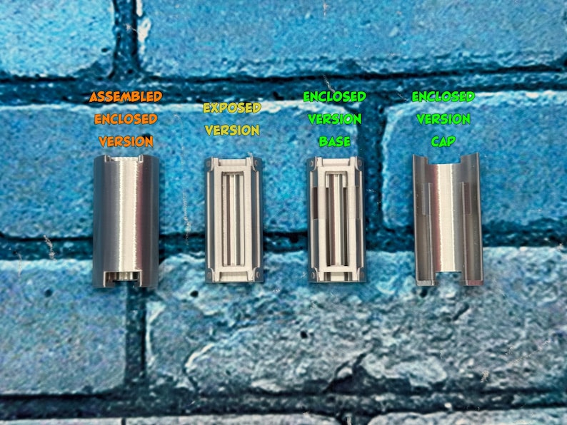 以下が含まれることがあります： 青いレンガの壁を背景に、4つの銀色の金属部品が表示されています。「組み立てられた密閉バージョン」、「露出バージョン」、「密閉バージョンベース」、および「密閉バージョンキャップ」とラベル付けされています。コンポーネントは、より大きなデバイスの一部であるようです。