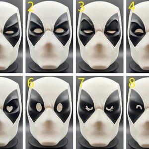 Puede incluir: Ocho m&aacute;scaras blancas de Deadpool con diferentes dise&ntilde;os de ojos. Las m&aacute;scaras tienen agujeros negros para los ojos y una boca negra.