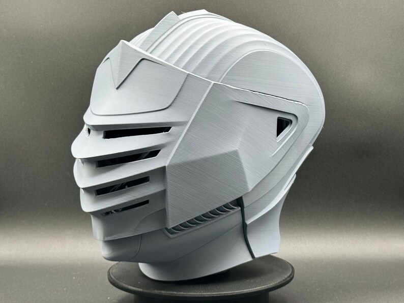 Puede incluir: Un casco blanco impreso en 3D con una visera y un dise&ntilde;o detallado. El casco tiene una superficie texturizada y parece estar hecho de pl&aacute;stico.