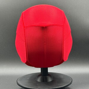 May include: Red mesh baseball cap with a curved brim. The cap is on a black display stand.