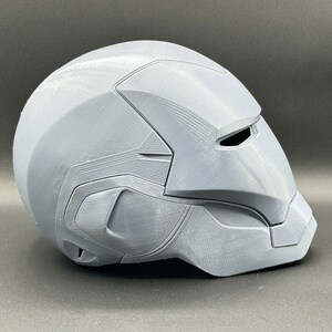 Puede incluir: Un casco gris impreso en 3D con una superficie texturizada y una visera.