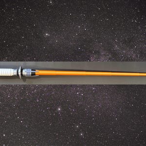 May include: An orange lightsaber with a silver and white hilt. The lightsaber is displayed against a starry background. The hilt features a white grip and silver accents. The blade is a bright orange color.