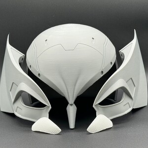 Puede incluir: Un casco blanco impreso en 3D con un dise&ntilde;o futurista. El casco tiene una parte superior grande y redondeada con una serie de crestas y ranuras. El casco tambi&eacute;n tiene dos grandes aberturas en forma de ojo en la parte delantera. El casco est&aacute; formado por varias piezas, incluyendo el casco principal, dos piezas laterales y dos piezas m&aacute;s peque&ntilde;as que cubren las aberturas de los ojos.