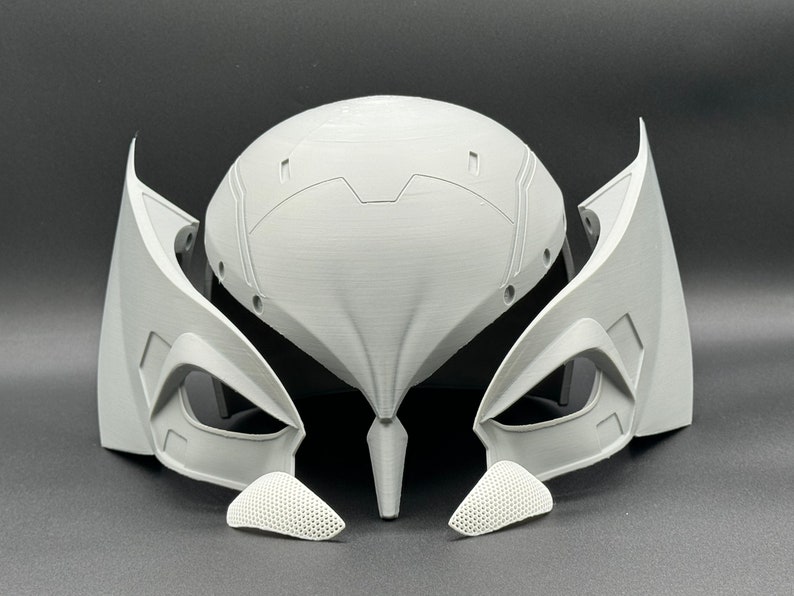 Puede incluir: Un casco blanco impreso en 3D con un dise&ntilde;o futurista. El casco tiene una parte superior grande y redondeada con una serie de crestas y ranuras. El casco tambi&eacute;n tiene dos grandes aberturas en forma de ojo en la parte delantera. El casco est&aacute; formado por varias piezas, incluyendo el casco principal, dos piezas laterales y dos piezas m&aacute;s peque&ntilde;as que cubren las aberturas de los ojos.