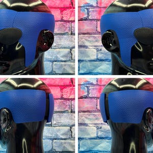 May include: A blue textured head wrap worn on a black mannequin head. The wrap features a honeycomb pattern across the surface, covering the forehead and extending down the sides toward the ears, with dark oval eye coverings visible.