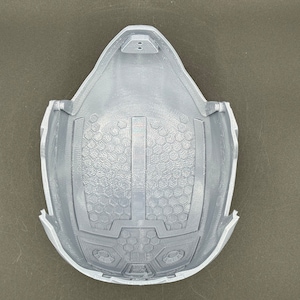 Puede incluir: Un casco gris impreso en 3D con un patr&oacute;n de panal en el interior. El casco tiene una secci&oacute;n elevada en la parte superior con dos peque&ntilde;os agujeros.