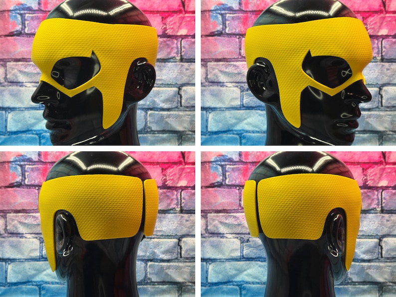 K&ouml;nnte beinhalten: Eine leuchtend gelbe, texturierte Superheldenmaske auf einem schwarzen Schaufensterpuppenkopf. Die Maske hat ein breites Stirnband, spitze Augenausschnitte und Seitenteile, die bis zum Kiefer reichen und das Gesicht sowie die Ohren bedecken.