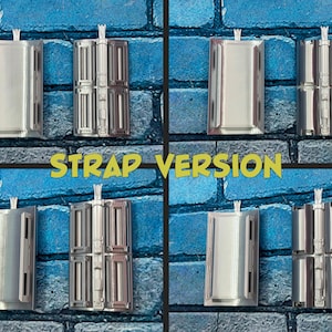 以下が含まれることがあります： 青いレンガの壁を背景に、銀色の金属製ストラップコンポーネントのコレクション。テキスト「STRAP VERSION」は黄色の文字です。コンポーネントは、さまざまなデザインの長方形です。