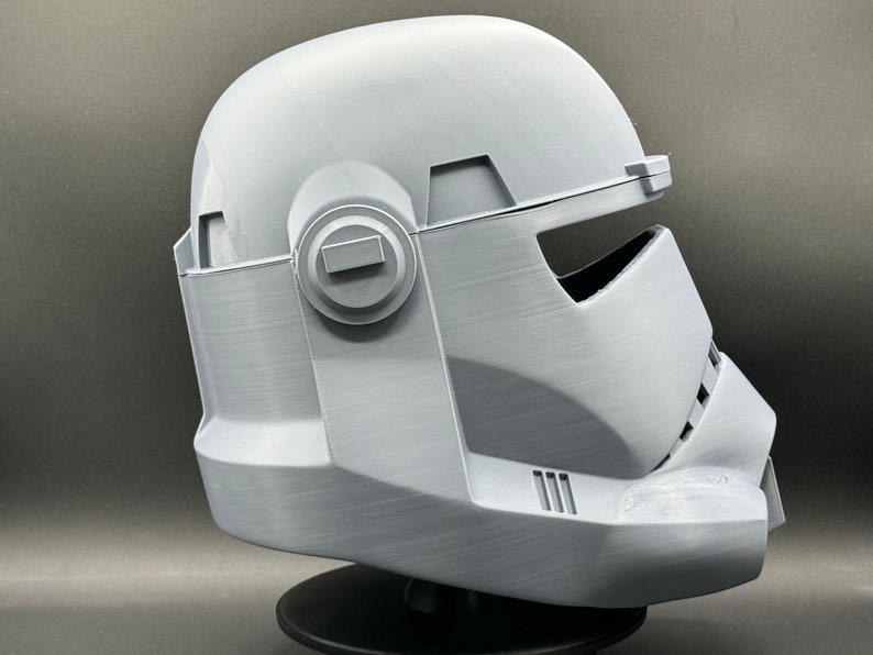 May include: A white plastic helmet with a visor and a textured surface. The helmet is designed to resemble a Star Wars character.