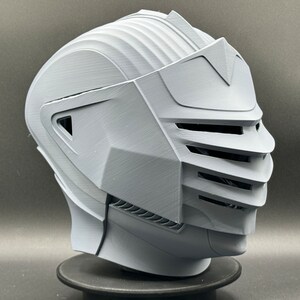 Puede incluir: Un casco blanco impreso en 3D con una visera y una superficie texturizada.