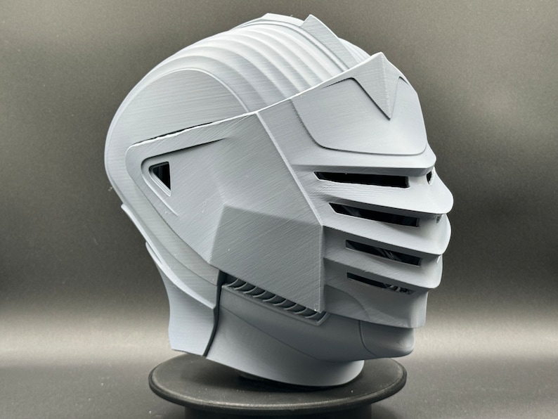 Puede incluir: Un casco blanco impreso en 3D con una visera y una superficie texturizada.