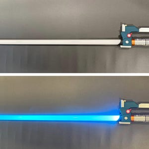 May include: A toy lightsaber with a white blade and a detailed handle in teal, gray, and orange. The second image shows the blade illuminated in bright blue.