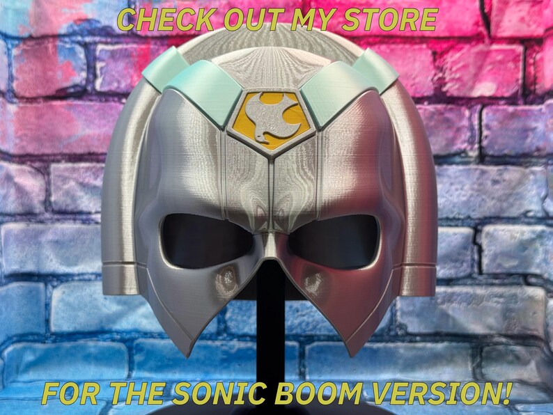May include: A silver and red helmet with a bird emblem on the front. The helmet has a visor and is displayed on a black stand. Text on the image reads "CHECK OUT MY STORE" and "FOR THE SONIC BOOM VERSION!"