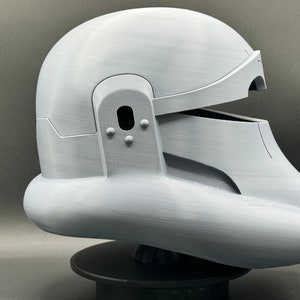 May include: A white 3D printed helmet with a visor and a textured surface.