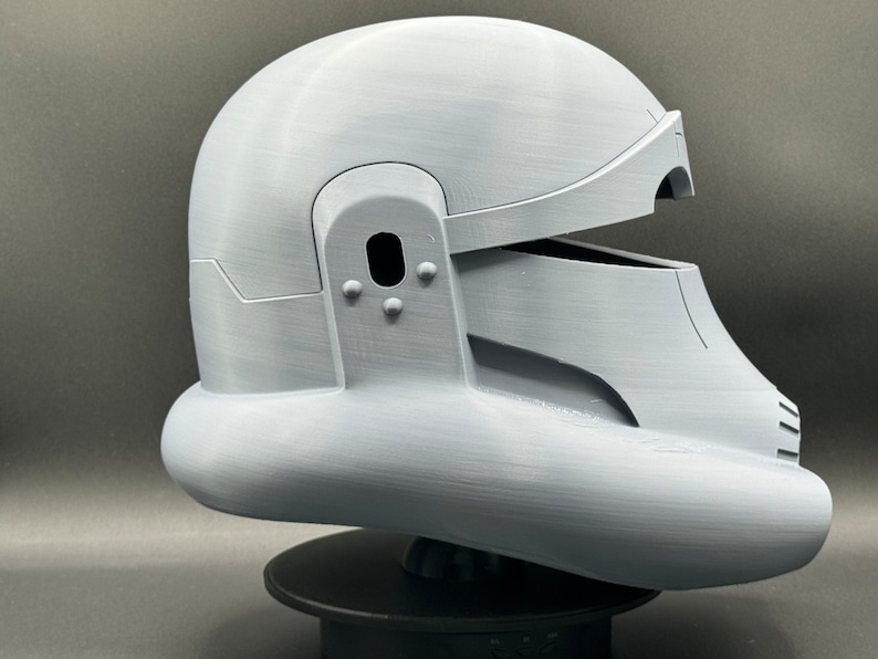 May include: A white 3D printed helmet with a visor and a textured surface.
