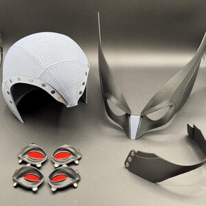 May include: A set of costume accessories including a white helmet, a black mask with white accents, a black headband, and four black eye pieces with red accents.