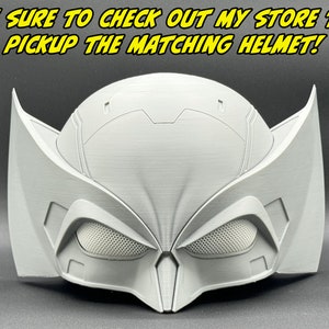 May include: A white plastic helmet with a textured surface and a black mesh visor. The helmet has a unique design with two large wings on the sides.