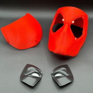 Puede incluir: Una m&aacute;scara de Deadpool de pl&aacute;stico rojo con dos piezas de ojos negras. La m&aacute;scara est&aacute; en cuatro piezas, con la parte principal de la m&aacute;scara, dos piezas laterales y dos piezas de ojos.