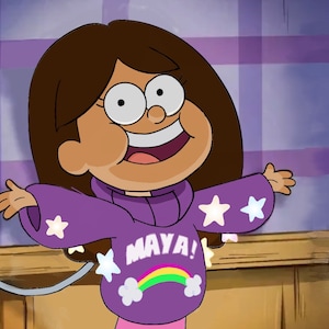Puede incluir: Una niña joven con cabello castaño lleva un suéter morado con estrellas blancas y el texto "MAYA!" en letras de arcoíris. Ella está sonriendo y tiene los brazos extendidos.