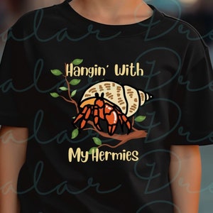 May include: A black t-shirt with a cartoon illustration of a hermit crab on a branch. The text "Hangin' With My Hermies" is printed on the shirt.