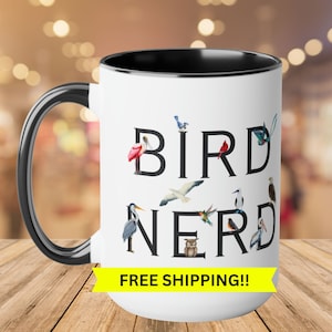 May include: White ceramic mug with a black rim and handle. The mug features the text "BIRD NERD" in black with various bird illustrations surrounding the letters. The text "FREE SHIPPING!!" is printed in yellow on a yellow banner at the bottom of the mug.