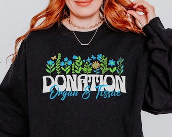 May include: Black sweatshirt with a floral design and the text "DONATION Organ & Tissue" in a retro font.