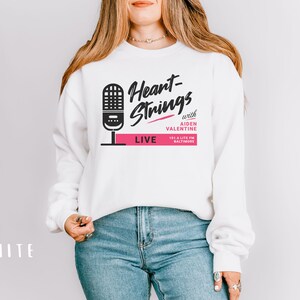 Puede incluir: Sudadera blanca con un gr&aacute;fico en blanco y negro de un micr&oacute;fono y el texto "Heart-Strings with Aiden Valentine 105.7 Lite FM Baltimore LIVE".