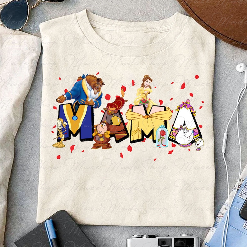 May include: A beige t-shirt with a graphic design of the word "MAMA" spelled out with characters from the Disney movie Beauty and the Beast. The characters include Belle, Beast, Cogsworth, and Mrs. Potts.