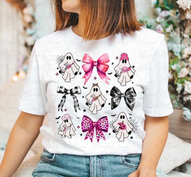 Op de afbeelding: Wit T-shirt met een roze, zwart en wit spook- en strikdesign. De spoken dragen hoeden en houden verschillende voorwerpen vast, waaronder een pompoen, een spinnenweb en een kopje koffie. De strikken zijn in verschillende patronen, waaronder ruit, stippen en effen kleuren.