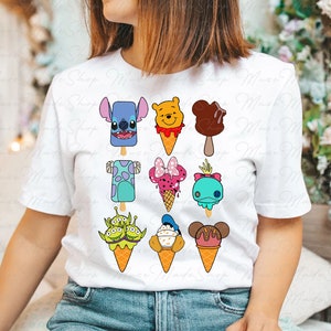 Puede incluir: Camiseta blanca con un dise&ntilde;o colorido de varios personajes de Disney en conos de helado y paletas. Los personajes incluyen Stitch, Winnie the Pooh, Mickey Mouse, Mike Wazowski, Minnie Mouse, Dory, Alien, Donald Duck y Goofy.