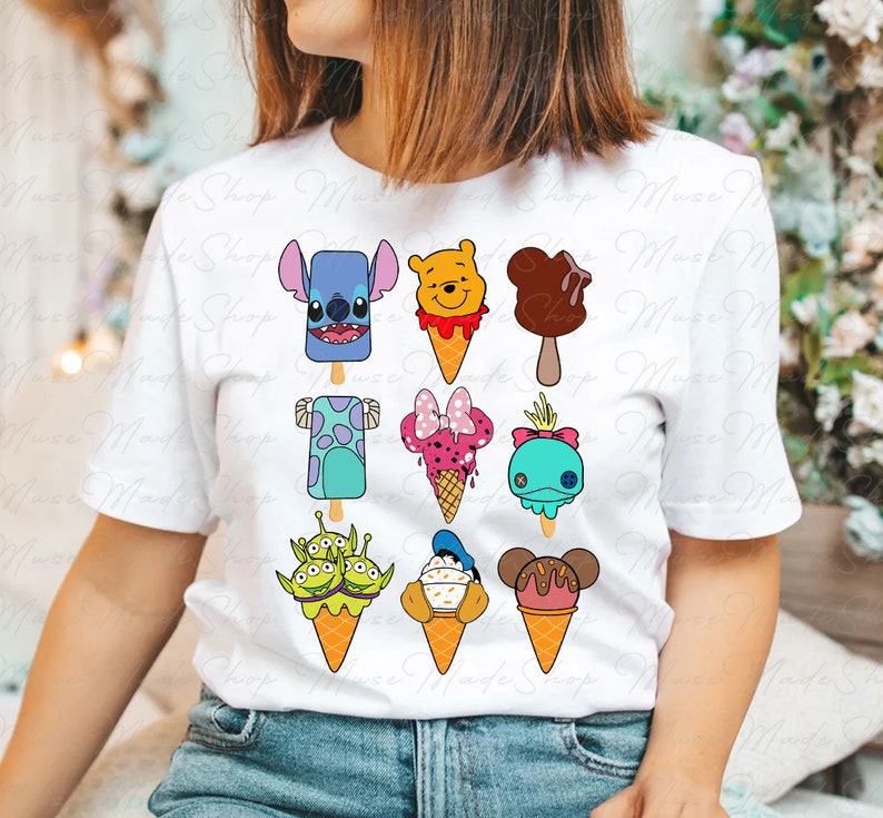 Puede incluir: Camiseta blanca con un dise&ntilde;o colorido de varios personajes de Disney en conos de helado y paletas. Los personajes incluyen Stitch, Winnie the Pooh, Mickey Mouse, Mike Wazowski, Minnie Mouse, Dory, Alien, Donald Duck y Goofy.