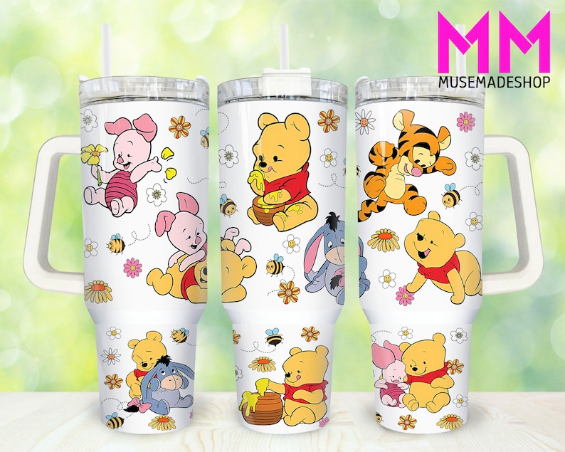May include: Three white stainless steel tumblers with a handle and a straw. Each tumbler features a different Winnie the Pooh character with a honey pot and bees. The tumblers are decorated with flowers and bees. The text 'MM' and 'MUSEMADESHOP' is visible in the top right corner of the image.