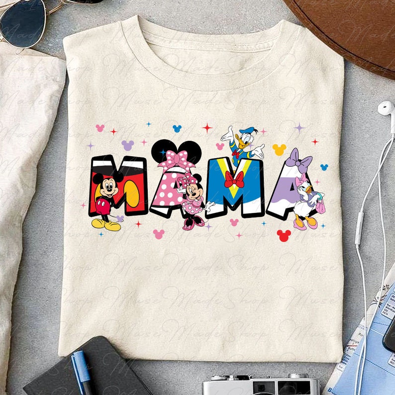 May include: A beige t-shirt with a colorful graphic of Mickey Mouse, Minnie Mouse, Donald Duck, and Daisy Duck spelling out the word "MAMA".