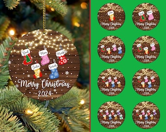 May include: A round wooden Christmas ornament with a rustic brown background and white lights. The ornament features a family of six stockings with names and the text "Merry Christmas - 2024".