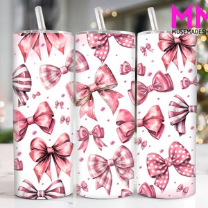 May include: A white tumbler with a pink and white bow pattern. The tumbler has a straw and is perfect for holding hot or cold beverages.